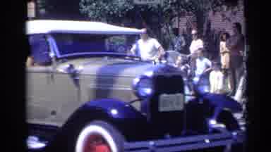 California USA (1969): Old Fashioned Cars Pass Eagle-Eyed Pedestrians On The