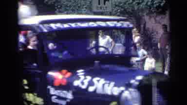 California USA (1969): Cars Driving Down The Road With People On The Sidelines