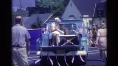 California USA (1969): A Truck With A Lot Of American Flags With People Sitting On