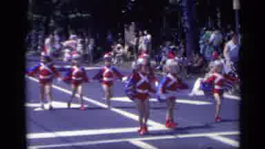 California USA (1969): Young Girls In Red Dresses March In A Summer Days Parade