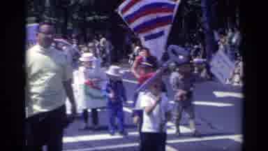 California USA (1969): Kids And Adults Walking In The Street In A Parade Style