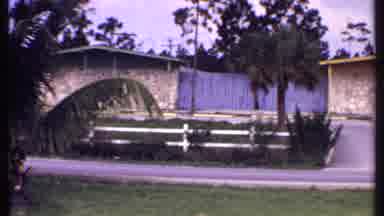 Bahamas (1969): Tan Colored Bungalows And Green Trees On A Clear Day