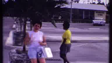Bahamas (1969): Woman In A White Shirt Leaning On A Stone Planter While A Woman In
