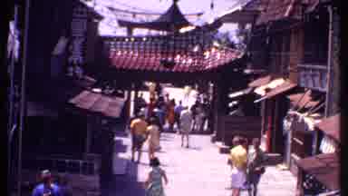 Bahamas (1969): People Walking Down A Tourist Street With Chinese Shop Signs