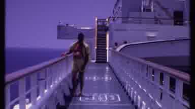Bahamas (1969): Man In A Yellow Outfit Tugs At His Crotch As He Walks Forward