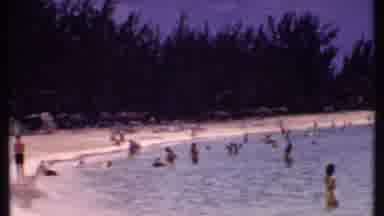 Bahamas (1969): Scene Sweeps From Water Filled With Swimmers To Beach Front With