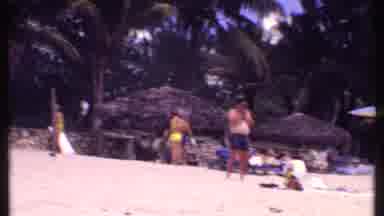 Bahamas (1969): Woman Wearing Black Swimwear Stands On Beach On A Clear Day