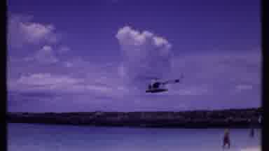 Bahamas (1969): An Helicopter Flying Over The Ocean Above A Rock Barrier