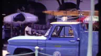 Bahamas (1969): Black Man Walks By Blue Vehicle Then White Man Walks Past Vendor