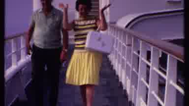 Bahamas (1969): Woman Wearing Yellow Skirt Walks With Man Wearing Green Shirt