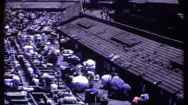 India-1969: People Washing Clothes Outdoors On Wooden Beams On A Bright Sunny Day