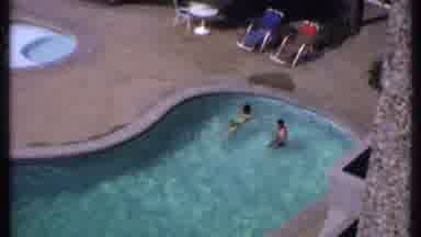 India (1969): Two People Swimming In A Pool At A Hotel As Seen From A Room On A