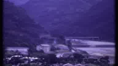 India (1969): The A Mountain Side Where You Can See Buildings And A Bridge