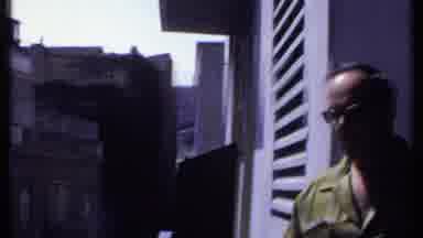 Kenya (1969): Smoking Man Looking Around At Buildings From The Balcony
