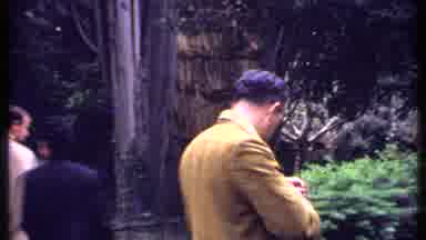 Kenya (1969): People Walking Around A Park With Lots Of Wood With Kenya Written On