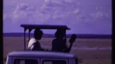 Kenya (1969): Big Field Of Grass With People In Car Driving By