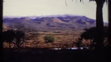 Kenya (1969): Mountain Range In The Desert With Trees And Some Water
