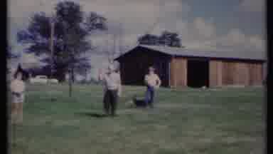 California USA (1971): People Standing Out In The Yard As Kid Plays With Dog