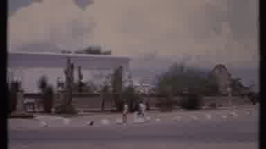 California USA (1971): Sweeping A Large White Building With Two People Walking In
