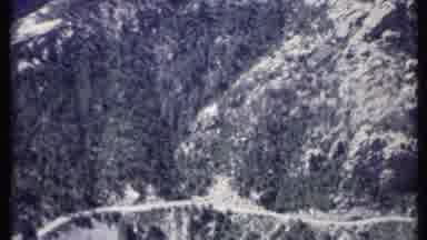 California USA (1971): A Long Dirt Road Cut Out Of A Mountain Side Covered In