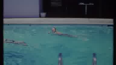 California USA (1971): Older Woman Swimming In A Pool Doing The Side Stroke