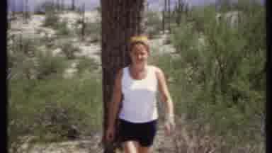 California USA (1971): Woman Walking Away From A Huge Tall Cactus In A Large