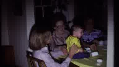 Ithaca New York (1979): A Women Sits At A Table Holding A Baby While Laughing And