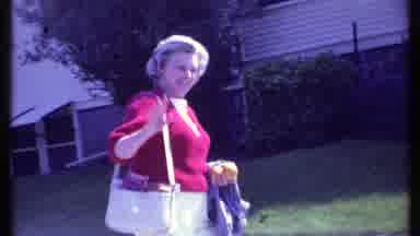 Vermont USA-1984: A Woman In A Red Sweater Waves At The Camera While Walking