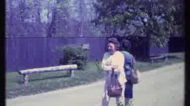 Vermont USA (1984): Two Older Women Wandering Around Carrying Bags In A Park Area