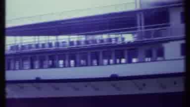 Vermont USA (1984): Woman Wearing Red Dress Walks Off White Boat On A Sunny Day