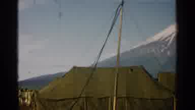 Japan (1952): Several Tents And A Very High Mountain Covered In Snow Over The