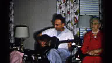 New Hampshire (1952): Man Sitting Down Playing Guitar With Grandma Sitting Next To