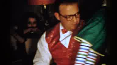 New Hampshire (1952): Man Wearing Red Vest Places Red And Green Toy On Floor