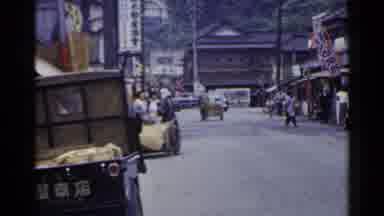 Japan (1953): Cart Goes Up Road Then Car Approaches Then Customers Enter A Market