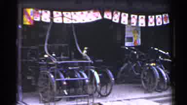 Japan (1953): Man Wearing White Shirt Places Bicycle On Bike Rack On A Clear Day