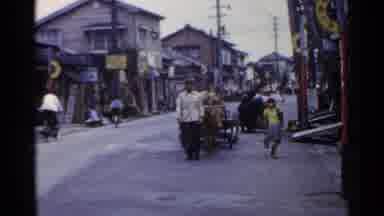 Japan (1953): Man And Cattle Pulling Cart Walk On Busy Street Alongside Child And