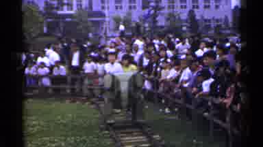Japan (1953): Person Wearing White Shirt Rides In Silver Object On A Clear Day