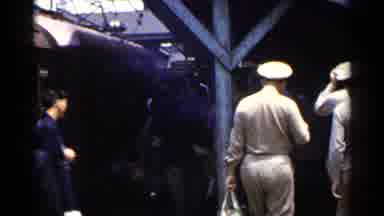 Japan (1953): People Walking At An Old Train Station And Some Are Wearing Uniforms