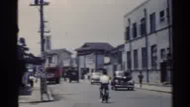 Japan (1953): Sweeping A Busy Small Town Street Lined With Stores Traffic And
