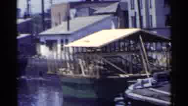 Japan (1953): People Walking Near A Boat Dock On A Sunny Day