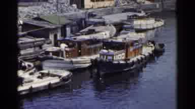 Japan (1953): Multiple Boats Gathering At Dock While Men Do Work On Deck