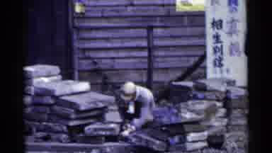 JAPAN-1953: Man Arranging Stone Blocks and Woman Preparing Goods on Street