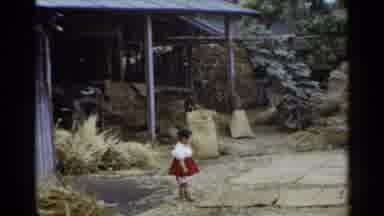Japan (1953): A Little Girl Standing On A Stone Pavement On A Wooden House