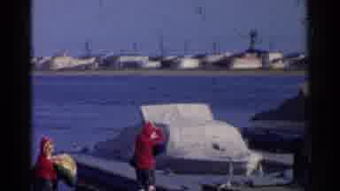 California-1955: People Dressed In Red At A Dock With White Boats