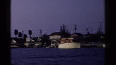 California-1955: Passing Brown Boat In Water On A Clear Sunny Day