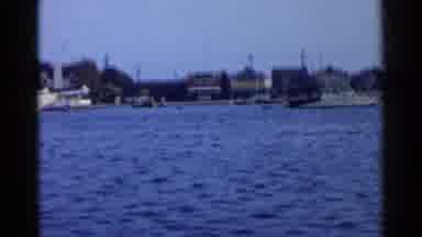 California (1955): Houses And Boats On A Body Water With Trees And Poles Around