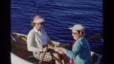 California (1955): Woman Enjoying Paddling Rowboat On A Lake With Her Friend