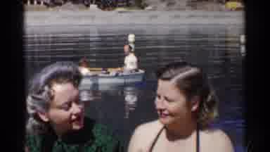 California (1955): Women Conversing On A Calm Lake While Two People Are Rowing