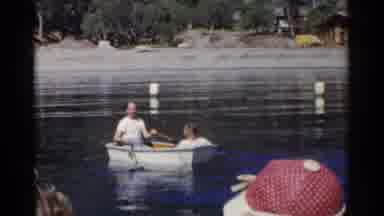 California (1955): Two Men Rowing On A Boat In A Small Lake As A Few People Stand