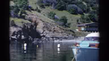 California (1955): Person Wearing Blue Pants Stands On Blue Boat On A Bright Sunny